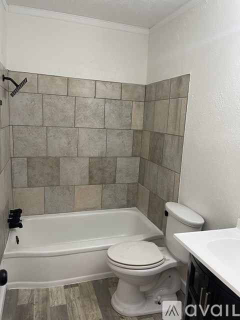 A bathroom with a toilet, tub, and sink.