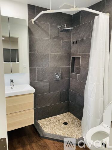 A bathroom with a white sink and a shower with a white curtain.