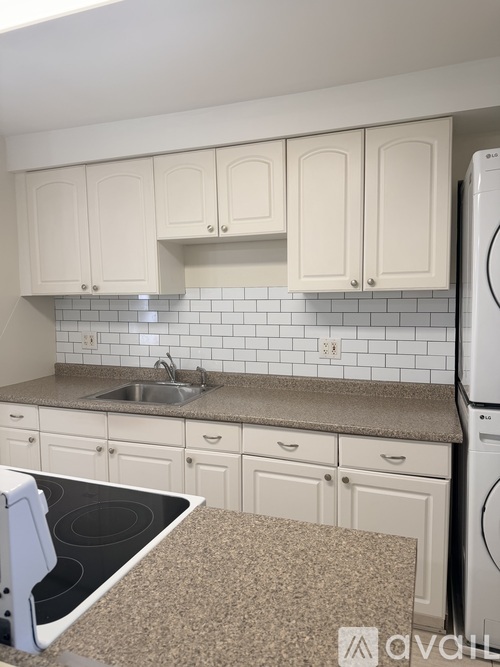 A kitchen with white cabinets and a black stove top.