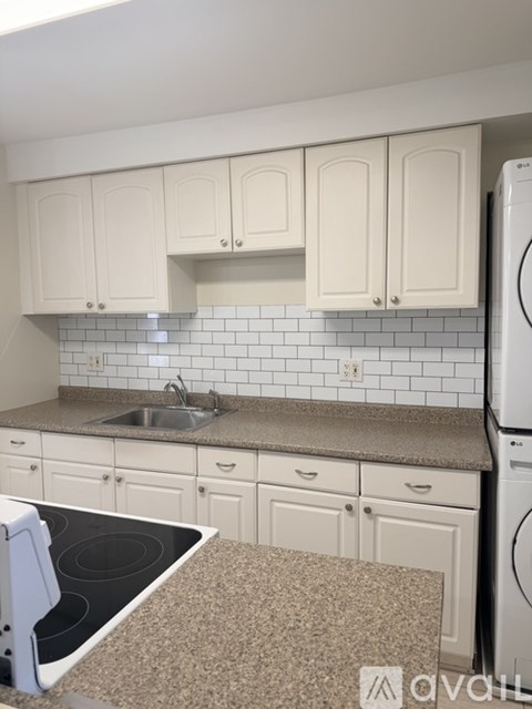 A kitchen with white cabinets and a black stove top.