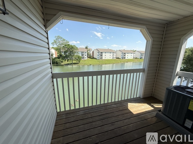 A balcony with a view of apartment buildings and a body of water.