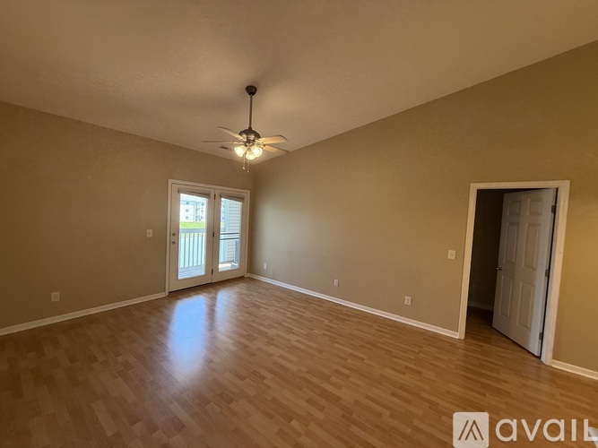 A room with a ceiling fan and wooden flooring.