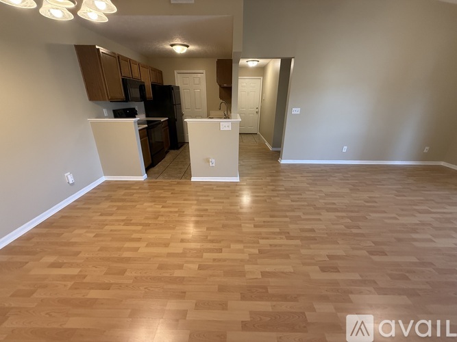 A kitchen area with wooden flooring and a white cabinet.