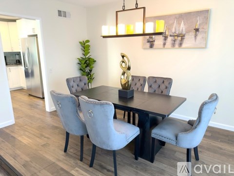 A dining room with a table and chairs.