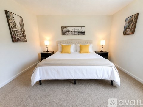 A bedroom with a large bed and two lamps on either side.