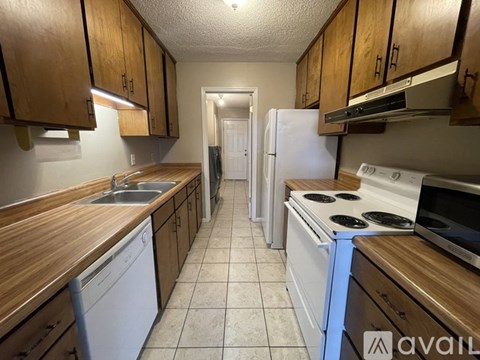 A kitchen with wooden cabinets and white appliances.