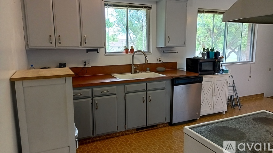 A kitchen with white cabinets and a wooden countertop.