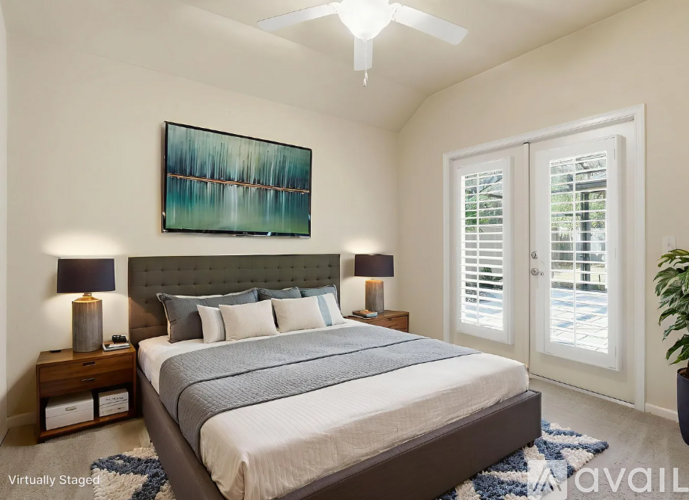 A bedroom with a large bed and a painting on the wall.