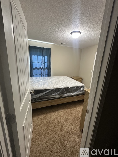 A bedroom with a bed and a window with blue curtains.