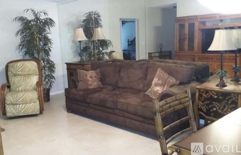 A living room with a brown couch and a chair.