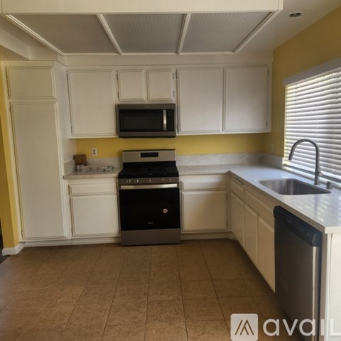 A kitchen with white cabinets and a black dishwasher.
