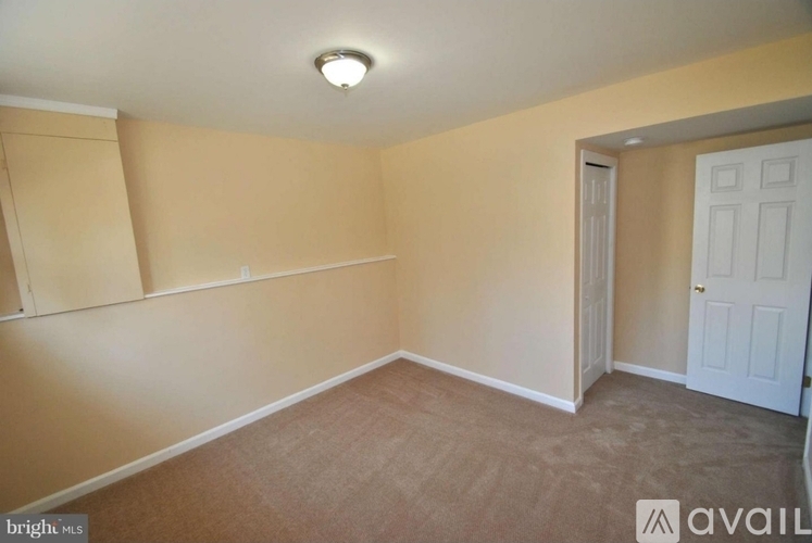 A room with a white door and a light on the ceiling.