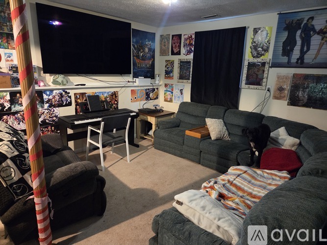 A living room with a couch, chair, and a television.