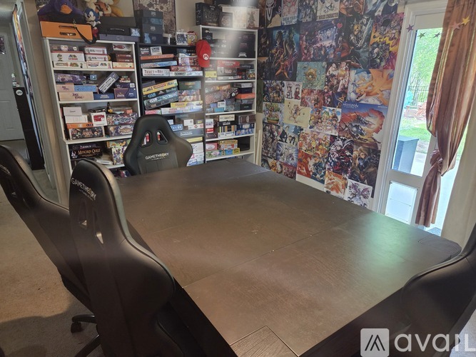 A room with a gaming chair and a wall covered in posters.