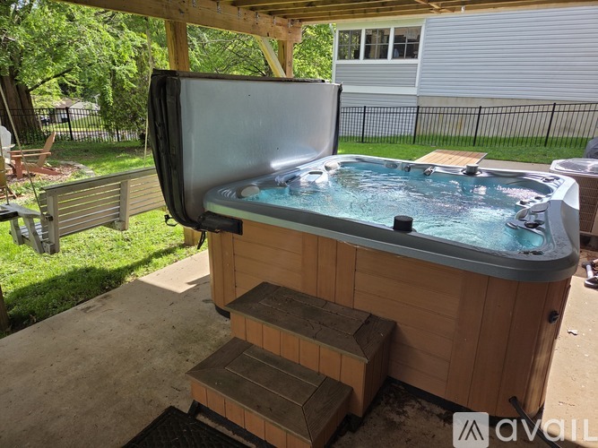A hot tub with a television on top is placed on a wooden deck.