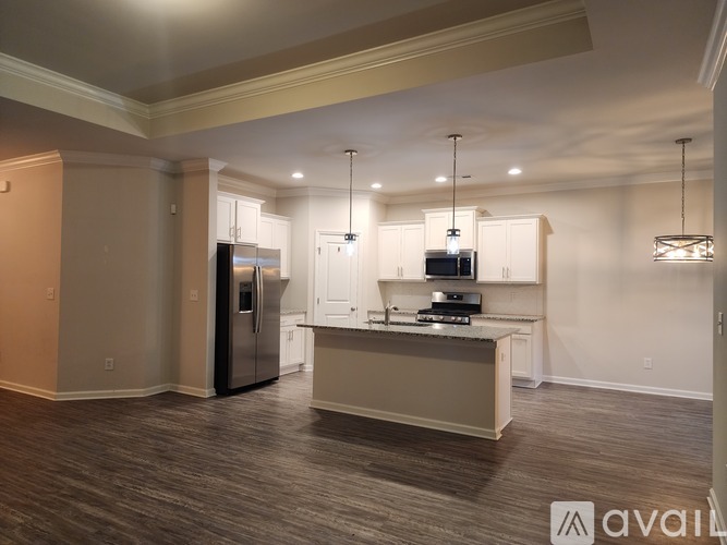A kitchen with a refrigerator, microwave, and oven is available for rent.