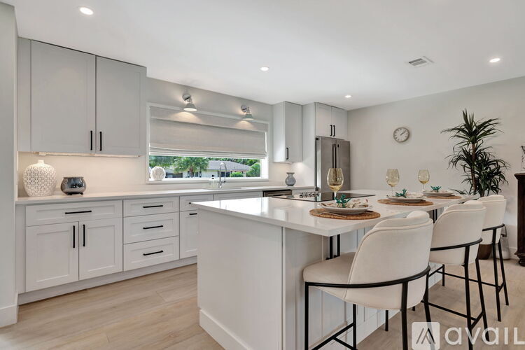 A modern kitchen with white cabinets and a large island.
