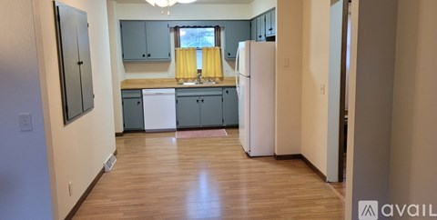 A kitchen with a white refrigerator and wooden floors.