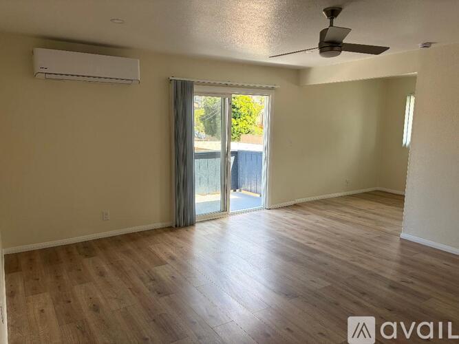 A room with wooden flooring and a ceiling fan.