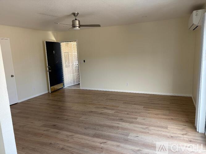 A room with a wooden floor and a ceiling fan.