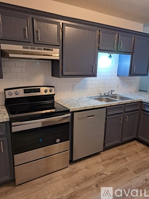 A kitchen with a stove top oven and a dishwasher.