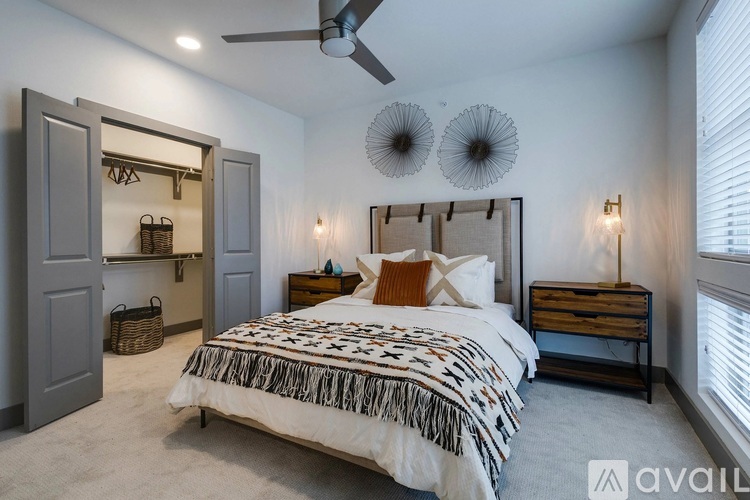 A bedroom with a large bed and a ceiling fan.