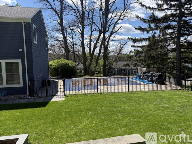 A blue house with a pool in the backyard.
