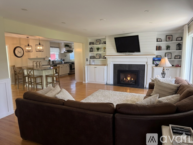 A living room with a brown couch and a fireplace.