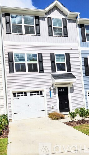 A two-story house with a garage and a black door.