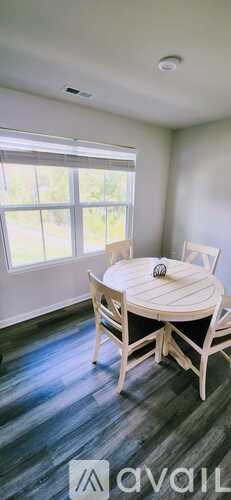 A dining room with a round table and chairs.