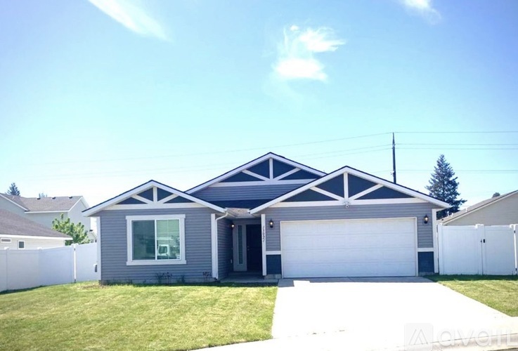 A house with a grey facade and a white garage door.