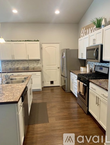 A kitchen with white cabinets and a granite countertop.