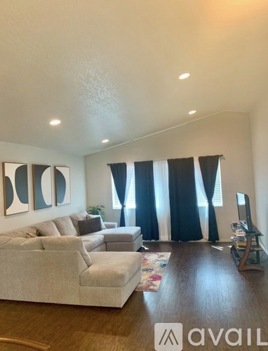 A living room with a grey sofa and a television.
