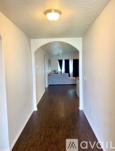 A long hallway with a bedroom at the end.