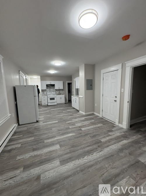 A long, narrow hallway with a wooden floor and white walls.