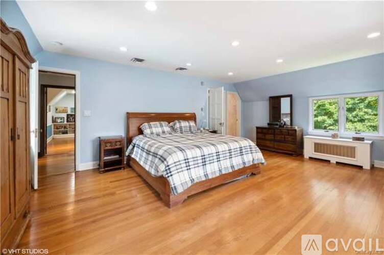 A bedroom with a large bed and wooden floors.