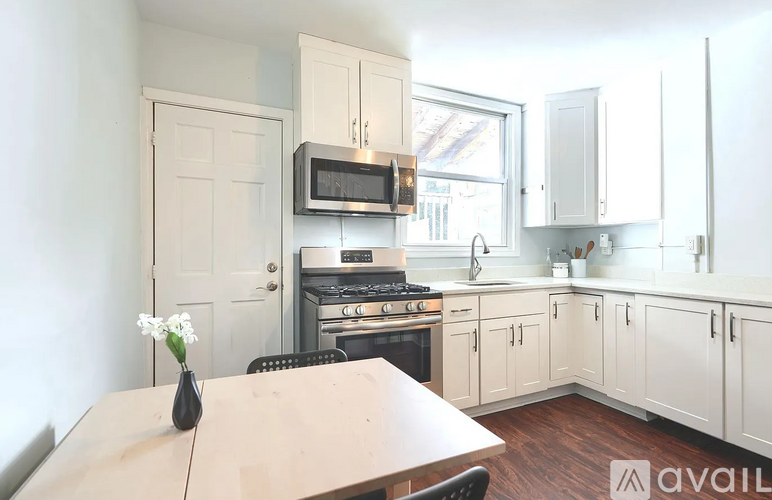 A kitchen with a table and chairs in front of it.