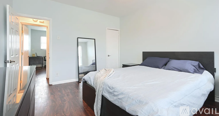 A bedroom with a large bed and a mirror on the wall.