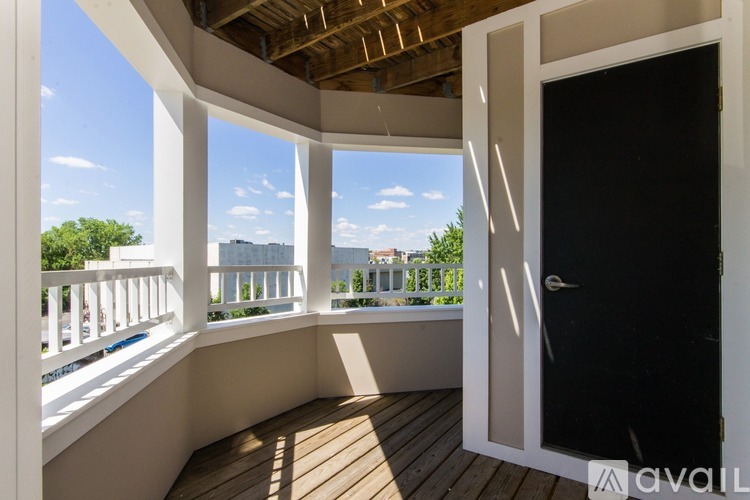 A balcony with a view of the cityscape and trees.