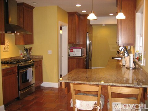 A kitchen with a table and chairs in front of it.