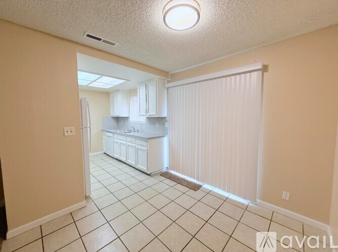 A kitchen with white cabinets and a white refrigerator is shown.