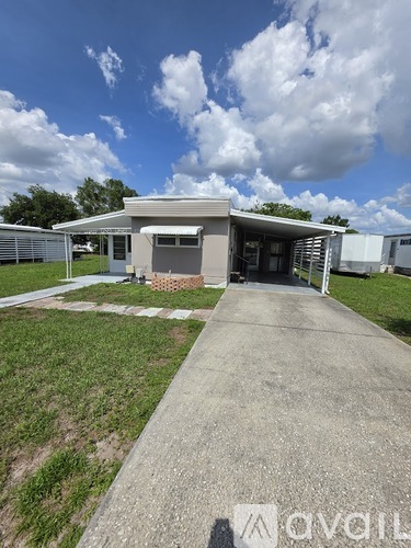 A concrete pathway leads to a small building with a grey roof.