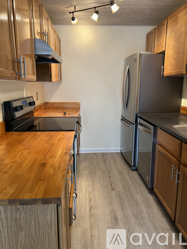 A kitchen with wooden cabinets and a stainless steel refrigerator.