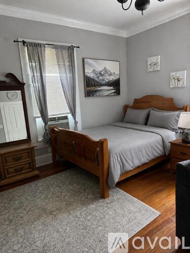 A bedroom with a bed, dresser, and a painting on the wall.