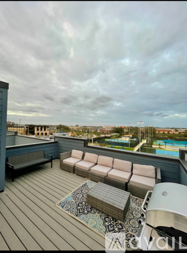 A rooftop patio with a pool in the distance.