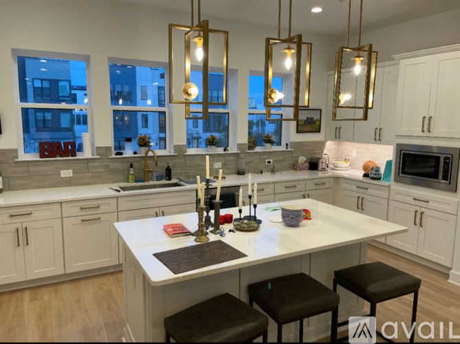 A kitchen with a large island and bar stools.