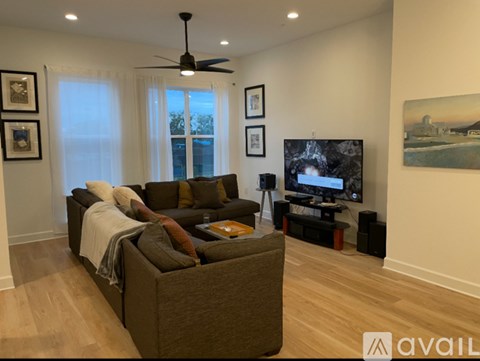 A living room with a brown couch and a television.