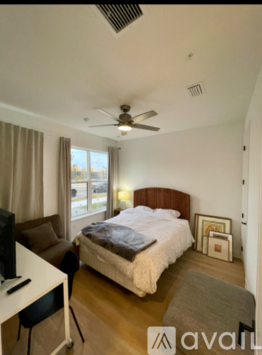 A bedroom with a bed, a chair, and a television.