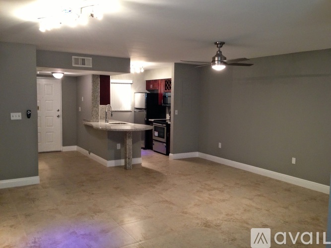 A spacious room with a table and chairs in the center.