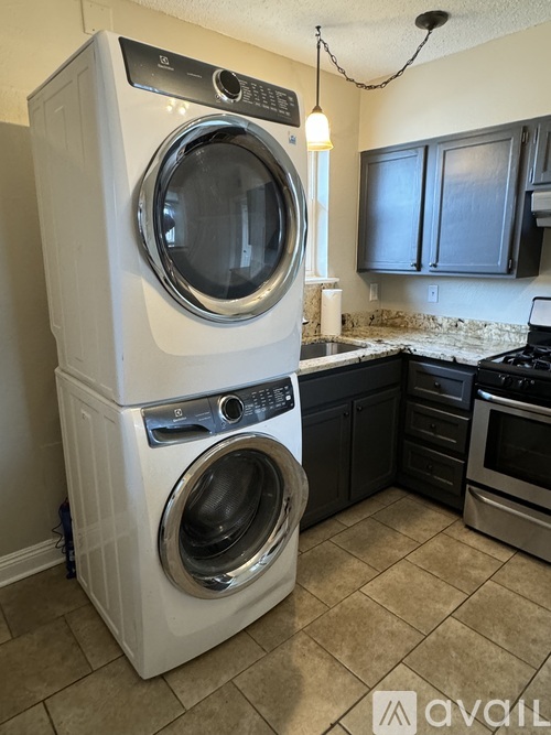 A white front load washing machine in a kitchen.